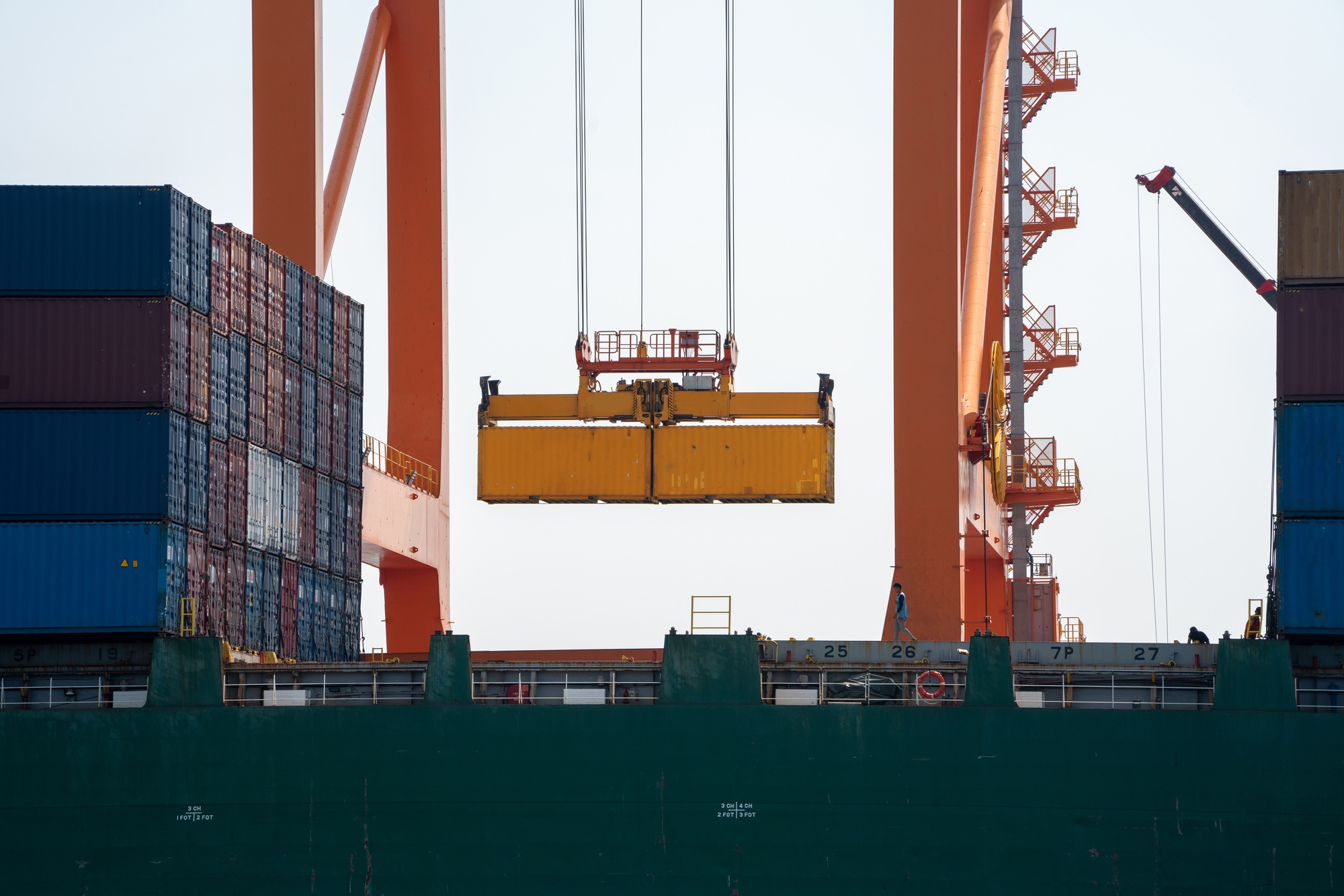 crane loading cargo container from truck to container ship in the international terminal logistic