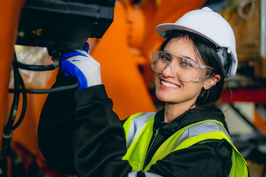 Professional maintenance worker with machine robotic arms at industrial factory